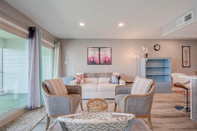 living area featuring light wood-style flooring, visible vents, and recessed lighting