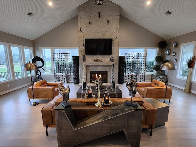 living area featuring high vaulted ceiling, a fireplace, visible vents, baseboards, and light wood-type flooring