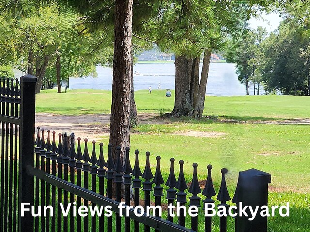 view of yard featuring a water view and fence