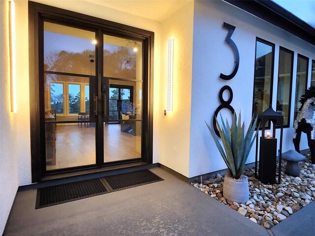 view of exterior entry with visible vents and stucco siding