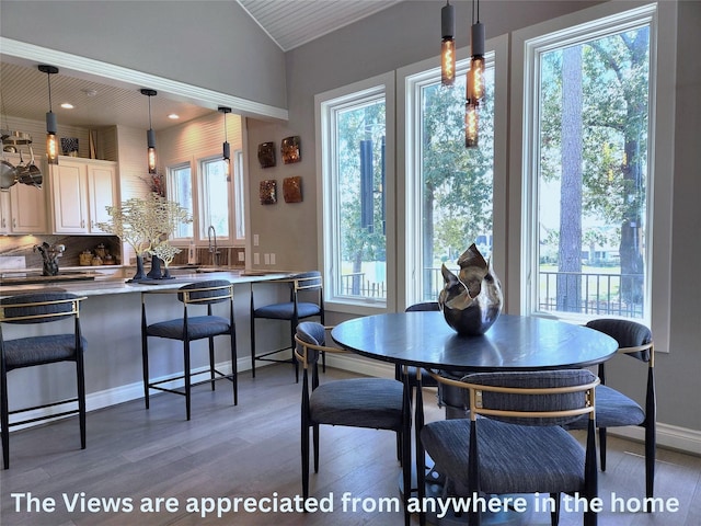 dining space with dark wood finished floors, vaulted ceiling, baseboards, and recessed lighting