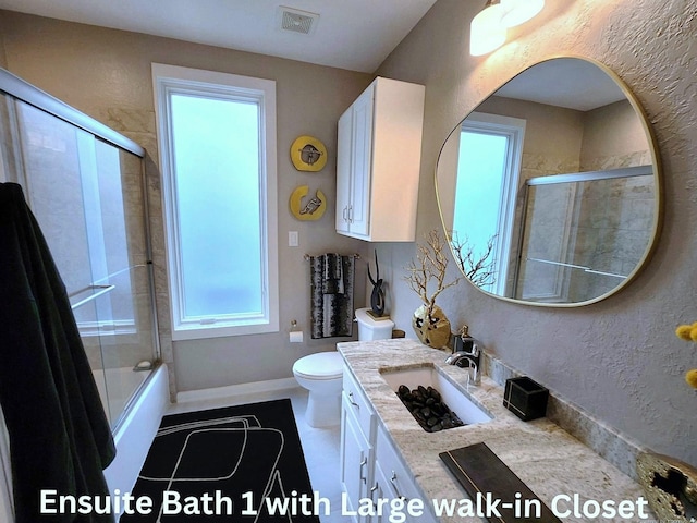 bathroom featuring enclosed tub / shower combo, a textured wall, toilet, vanity, and visible vents