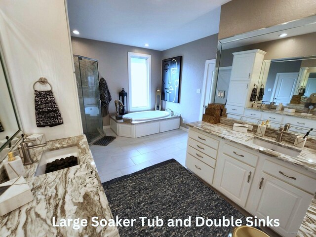 bathroom with recessed lighting, two vanities, a sink, a shower stall, and a bath