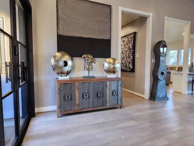 corridor with light wood-style floors and baseboards