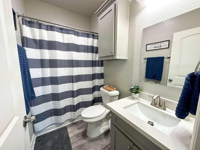 bathroom featuring vanity, hardwood / wood-style floors, curtained shower, and toilet