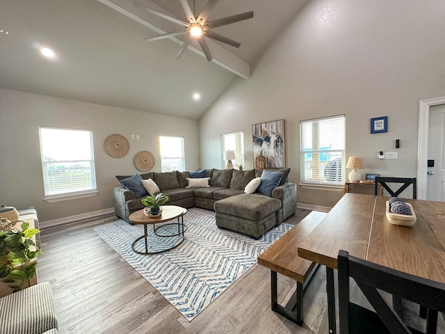 living room featuring beam ceiling, high vaulted ceiling, and light hardwood / wood-style flooring