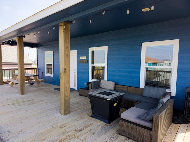 wooden deck with an outdoor living space with a fire pit