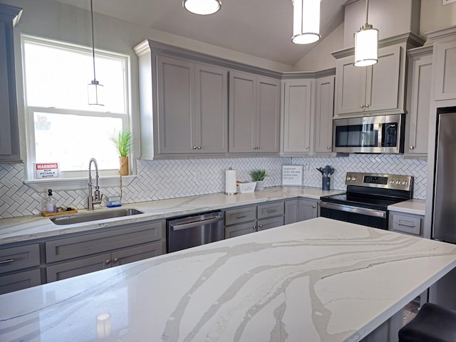 kitchen featuring hanging light fixtures, gray cabinets, sink, and appliances with stainless steel finishes