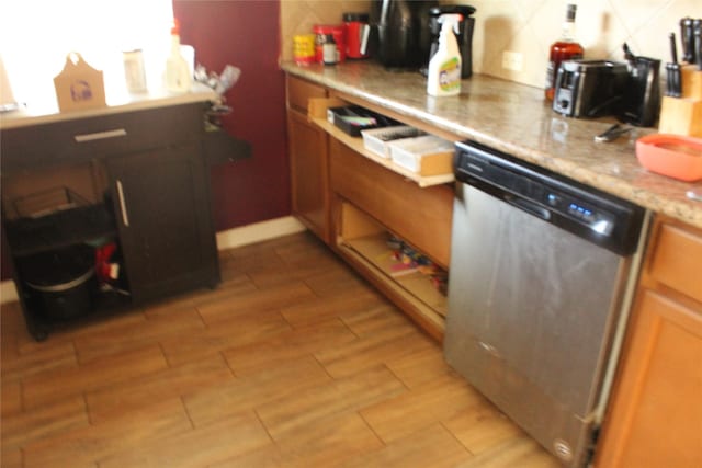 kitchen featuring tasteful backsplash, dishwasher, and light stone counters