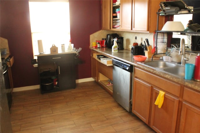 kitchen with sink, stainless steel dishwasher, and light hardwood / wood-style floors