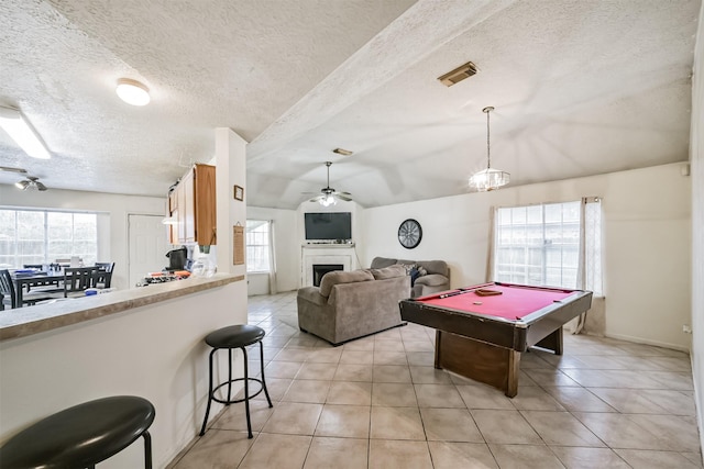 game room with vaulted ceiling, billiards, light tile patterned floors, ceiling fan, and a textured ceiling