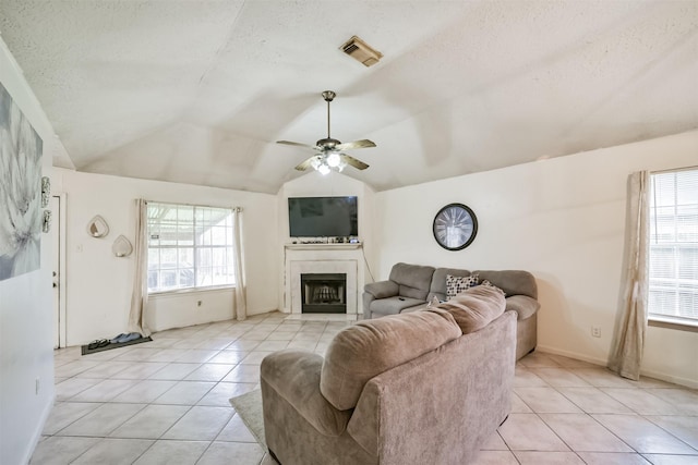 tiled living room with lofted ceiling, a textured ceiling, and ceiling fan