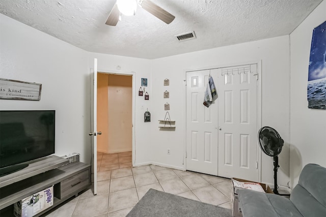 foyer entrance featuring ceiling fan, a textured ceiling, and light tile patterned floors