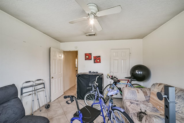 interior space with light tile patterned floors, a textured ceiling, and ceiling fan