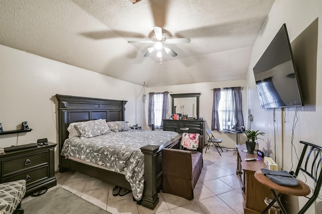 bedroom with vaulted ceiling, light tile patterned floors, ceiling fan, and a textured ceiling