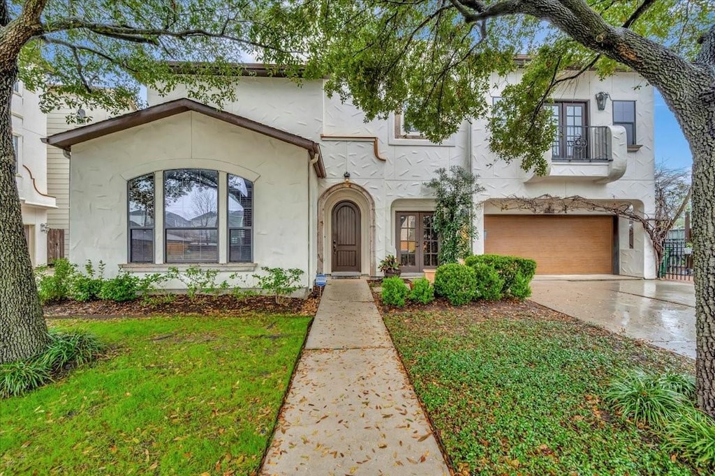 mediterranean / spanish-style house with a garage and a front lawn