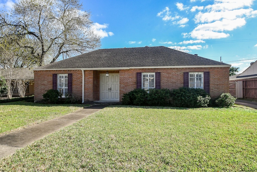 ranch-style home featuring a front lawn