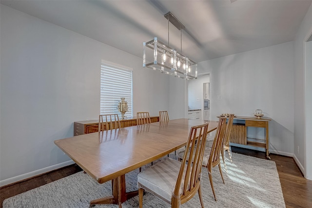 dining space with hardwood / wood-style flooring and a chandelier