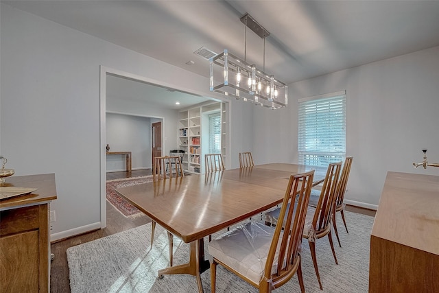 dining space with wood-type flooring and built in features