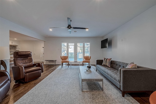 living room featuring dark wood-type flooring and ceiling fan