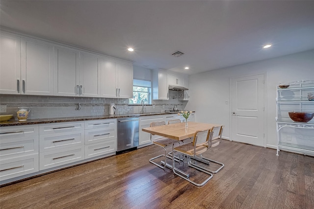 kitchen featuring wood-type flooring, sink, dark stone countertops, white cabinets, and stainless steel dishwasher