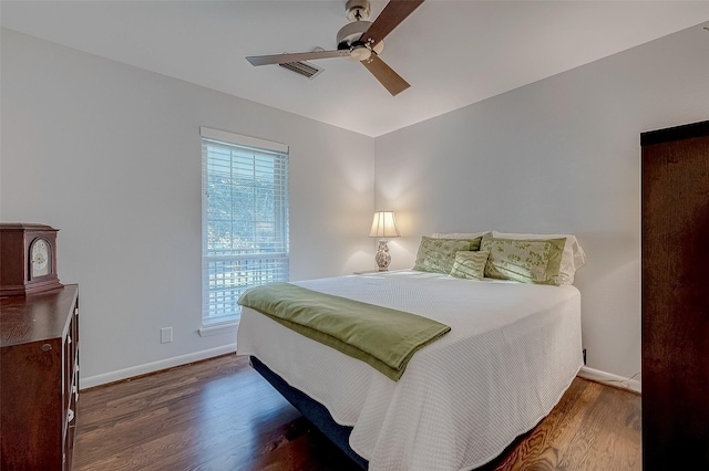 bedroom with dark wood-type flooring, ceiling fan, and multiple windows