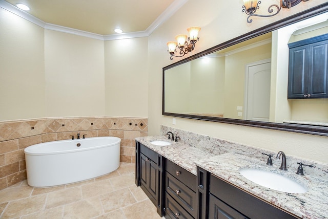 full bath with a sink, tile walls, a freestanding bath, double vanity, and crown molding