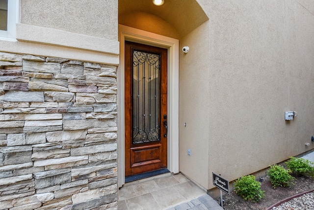 entrance to property with stone siding and stucco siding