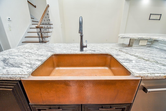 details featuring a sink, dark brown cabinetry, and light stone countertops