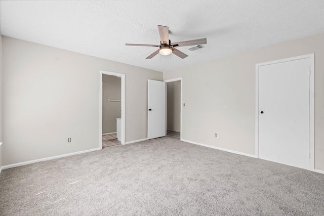unfurnished bedroom with light carpet, baseboards, visible vents, a ceiling fan, and ensuite bath