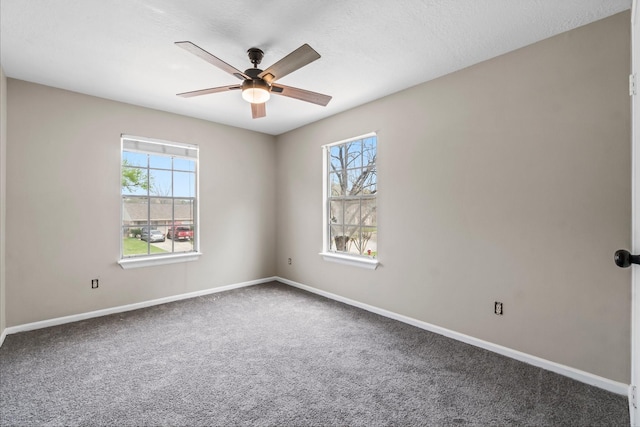 carpeted spare room with baseboards and ceiling fan