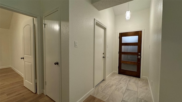 hall featuring light wood-type flooring and baseboards