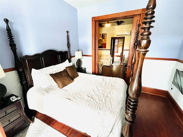 bedroom featuring dark wood-type flooring and a wall mounted air conditioner