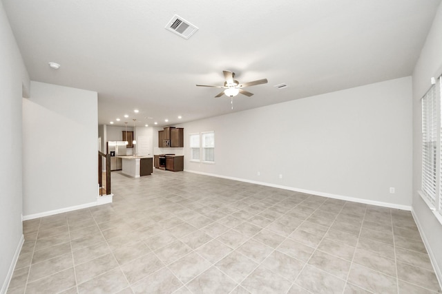 unfurnished living room featuring light tile patterned floors and ceiling fan