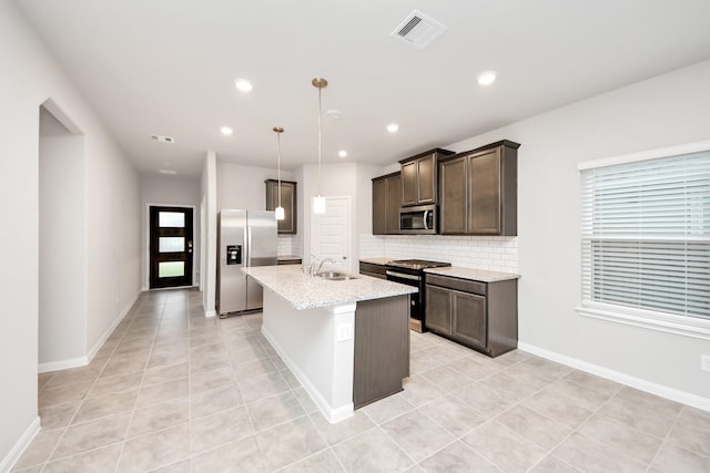 kitchen with sink, a center island with sink, appliances with stainless steel finishes, pendant lighting, and decorative backsplash