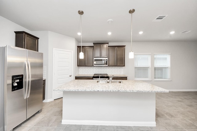 kitchen featuring hanging light fixtures, sink, an island with sink, and appliances with stainless steel finishes