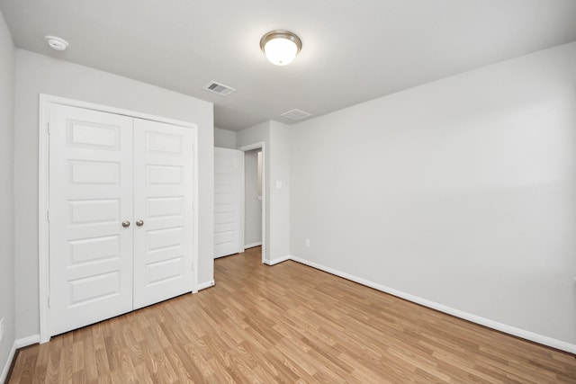 unfurnished bedroom featuring a closet and light hardwood / wood-style flooring