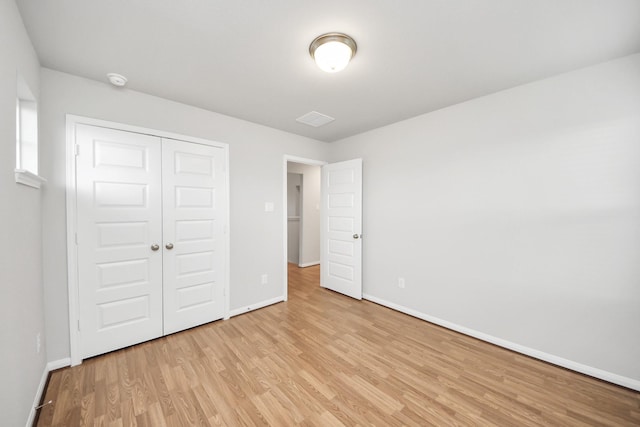 unfurnished bedroom featuring a closet and light wood-type flooring