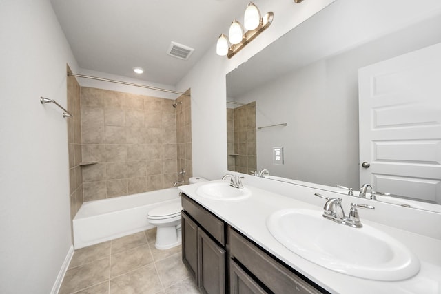 full bathroom featuring vanity, toilet, tiled shower / bath combo, and tile patterned flooring