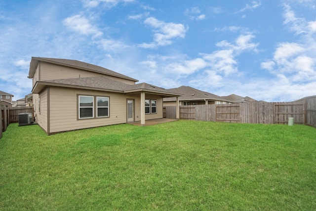 rear view of house featuring central AC and a yard