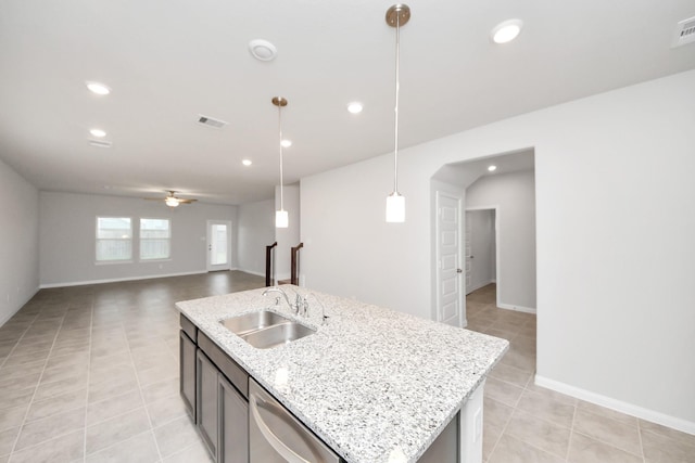 kitchen with sink, dishwasher, ceiling fan, hanging light fixtures, and an island with sink