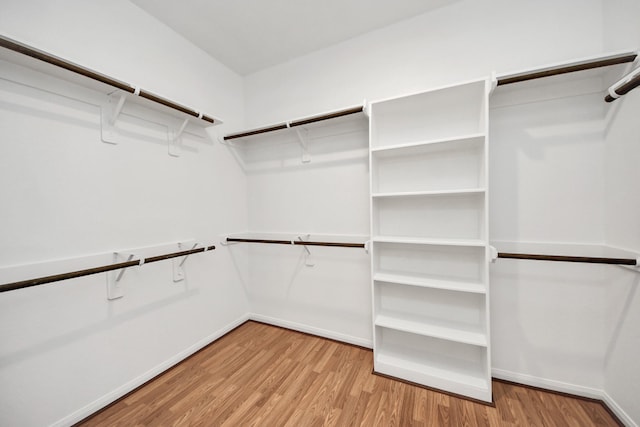 walk in closet with light hardwood / wood-style floors