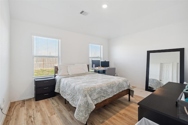 bedroom with light wood-type flooring, visible vents, and baseboards