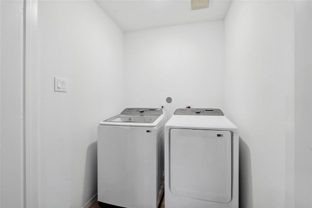 washroom with laundry area, washing machine and dryer, and visible vents