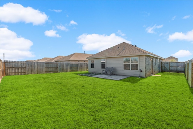 rear view of house with a yard, a patio, and a fenced backyard