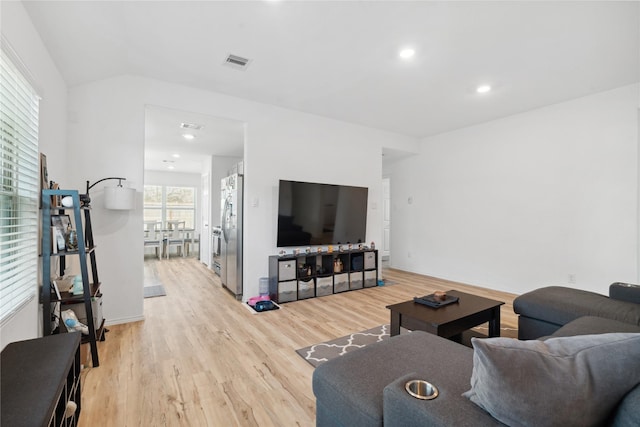 living room with lofted ceiling, light wood-style flooring, visible vents, and recessed lighting