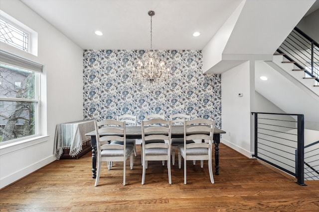 dining area with hardwood / wood-style flooring and a notable chandelier