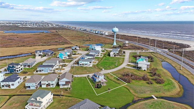 drone / aerial view with a water view, a residential view, and a view of the beach