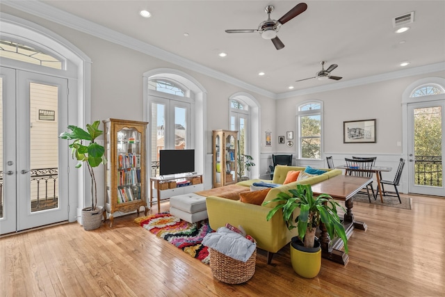 interior space featuring ornamental molding, plenty of natural light, light wood-type flooring, and french doors