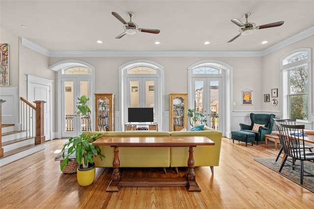 sitting room featuring light hardwood / wood-style flooring, ornamental molding, french doors, and ceiling fan